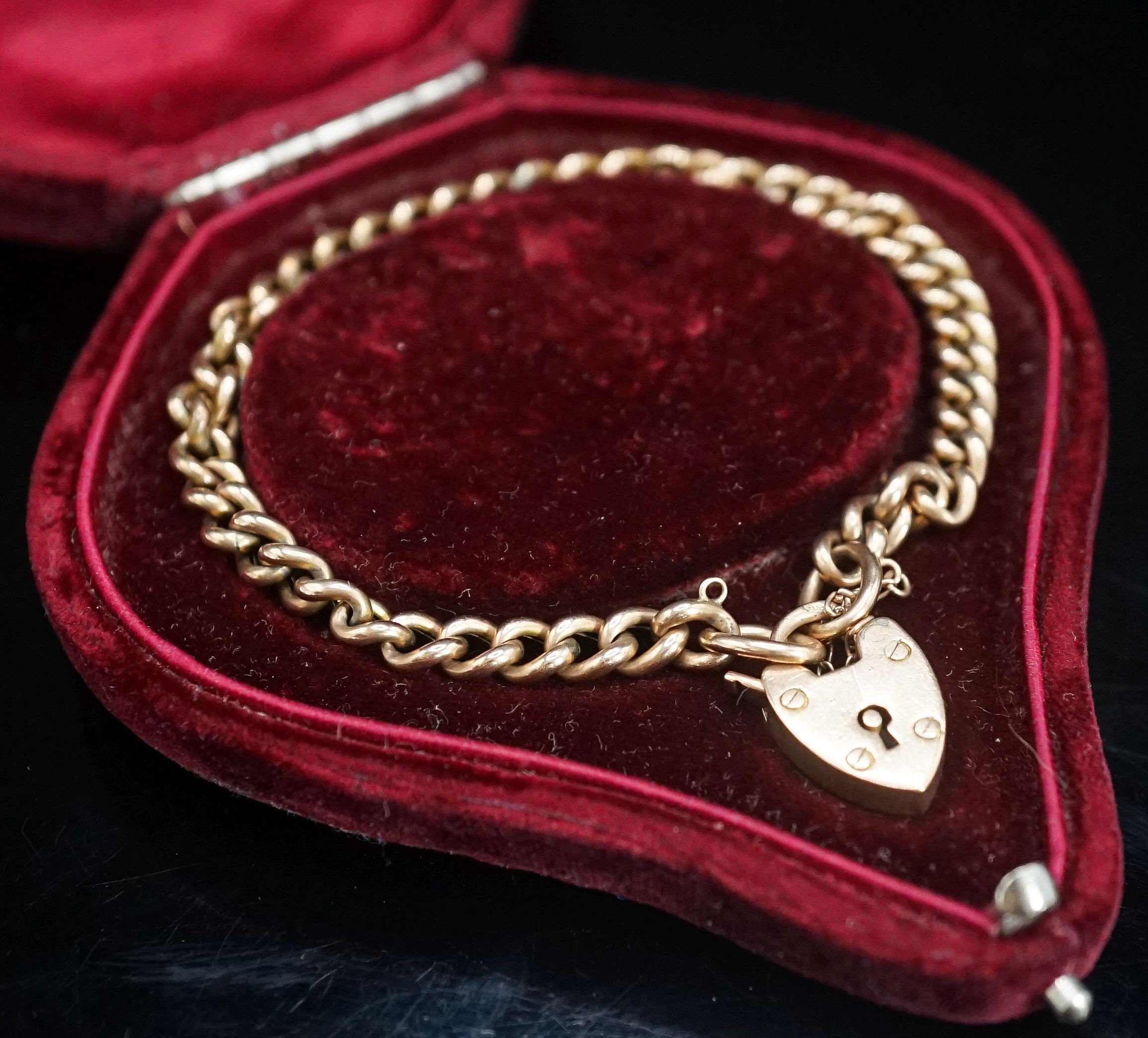 A 9ct gold curb link bracelet with heart shaped clasp (no key), 20cm, 10 grams.